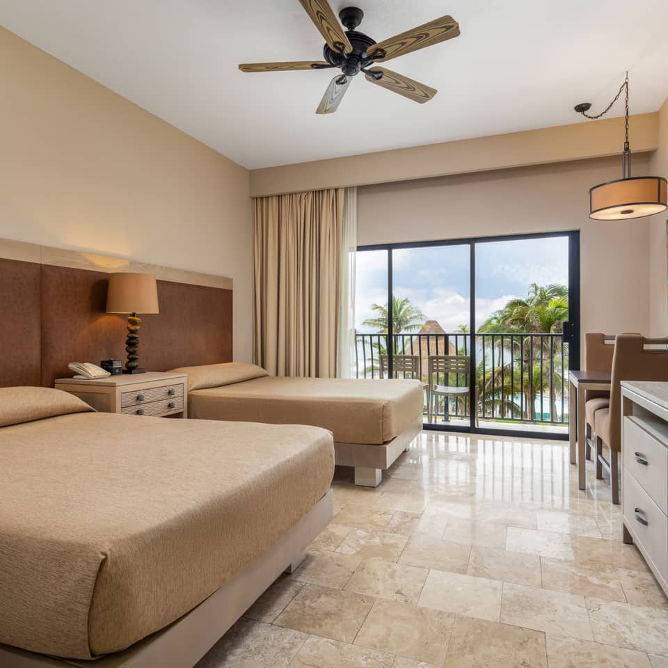 Oceanview guestroom with two beds and a private balcony.