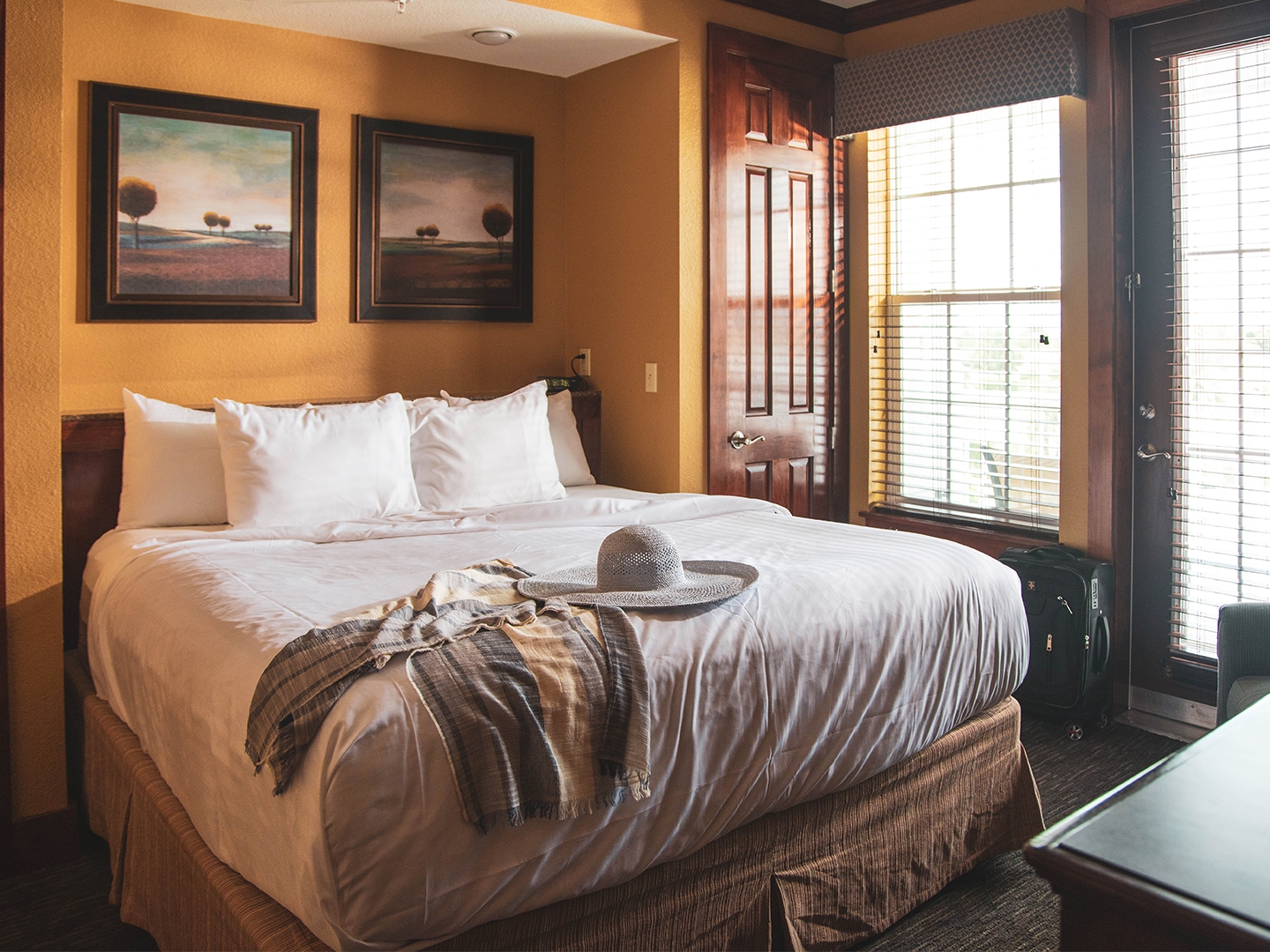 Bedroom with bed, window and access to patio/balcony in a two-bedroom villa at Orlando Breeze Resort in Florida.