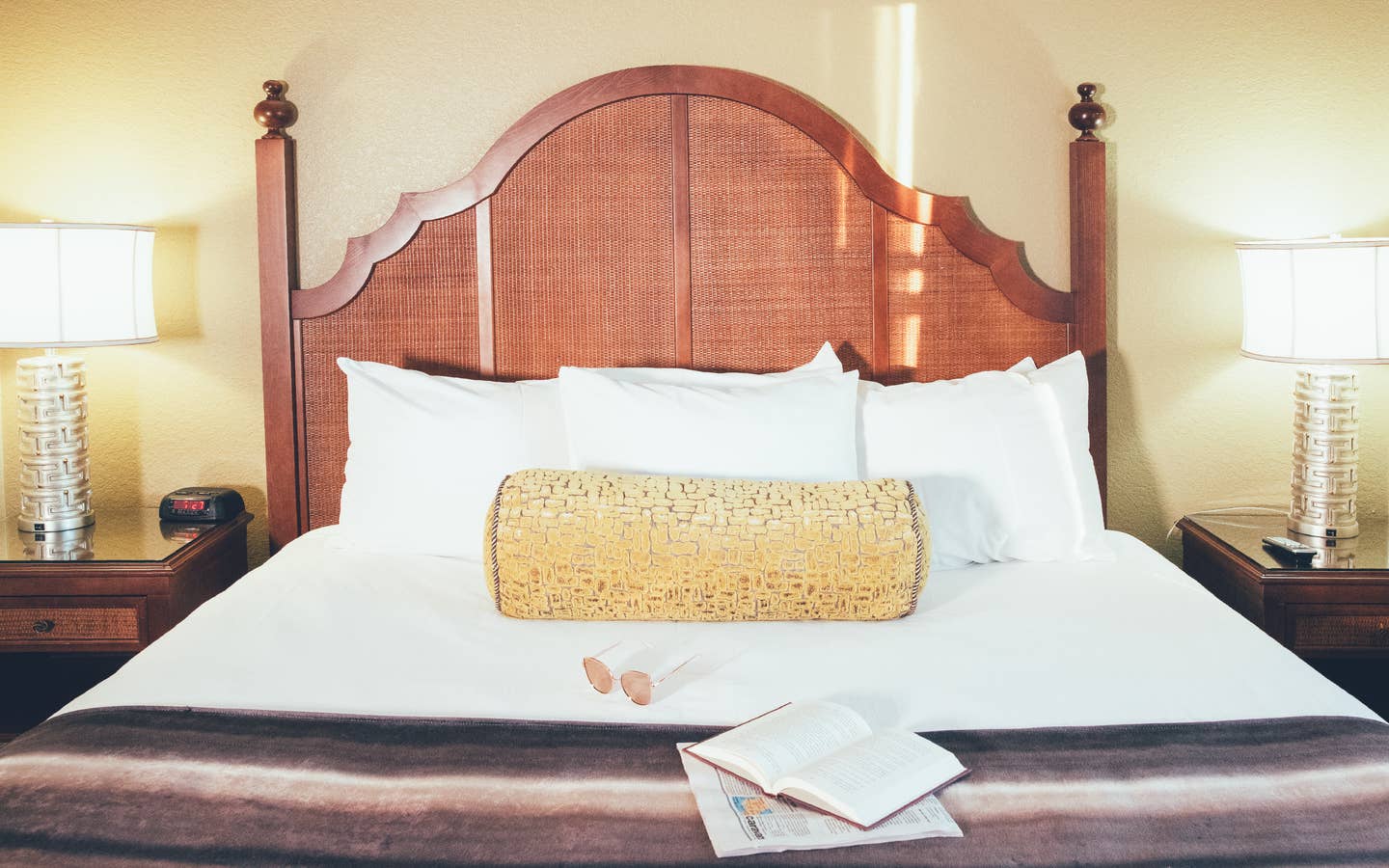 Bed with book and newspaper laying on top of covers in a Signature villa in River Island at Orange Lake Resort near Orlando, Florida