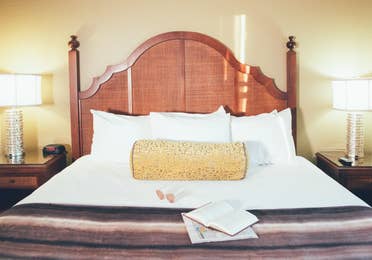 Bed with book and newspaper laying on top of covers in a Signature villa in River Island at Orange Lake Resort near Orlando, Florida