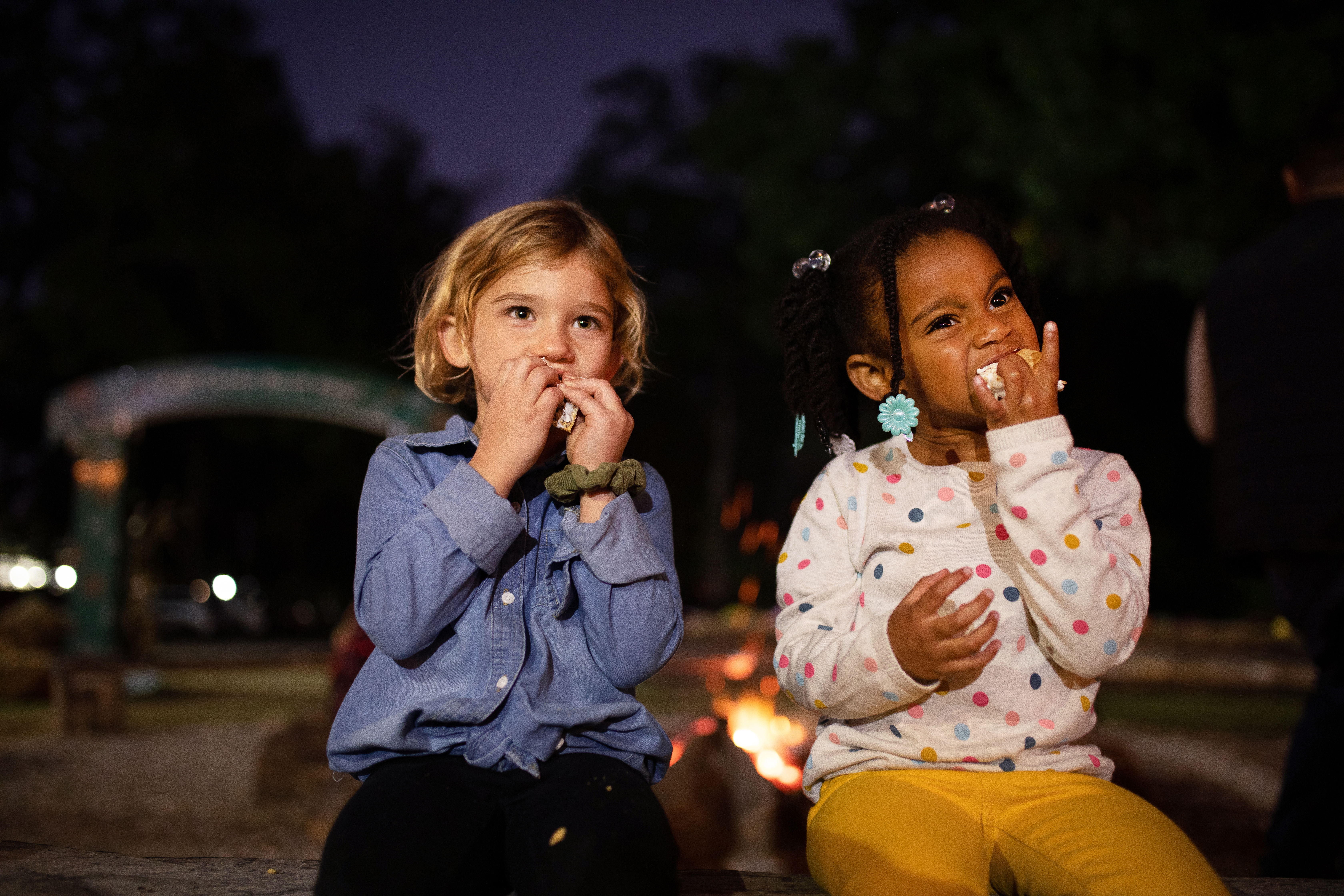 Two children eating s'mores outside during movie night at Falladays at Villages Resort.