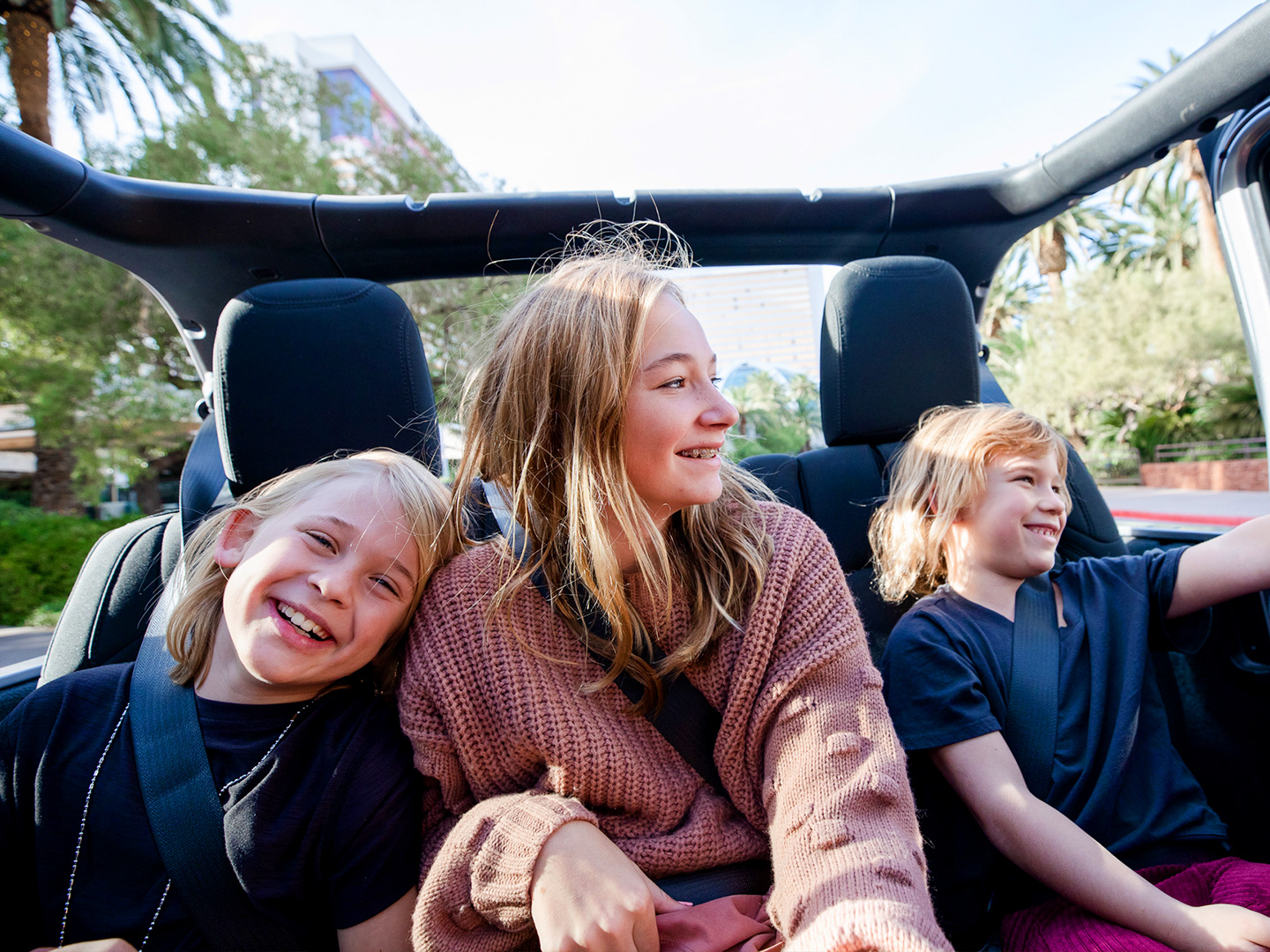 The Haby kids riding in the backseat of an open-top Jeep down the Vegas strip.