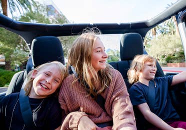 The Haby kids riding in the backseat of an open-top Jeep down the Vegas strip.