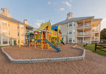 Outdoor children's playground outside of property buildings at Piney Shores Resort in Conroe, Texas.