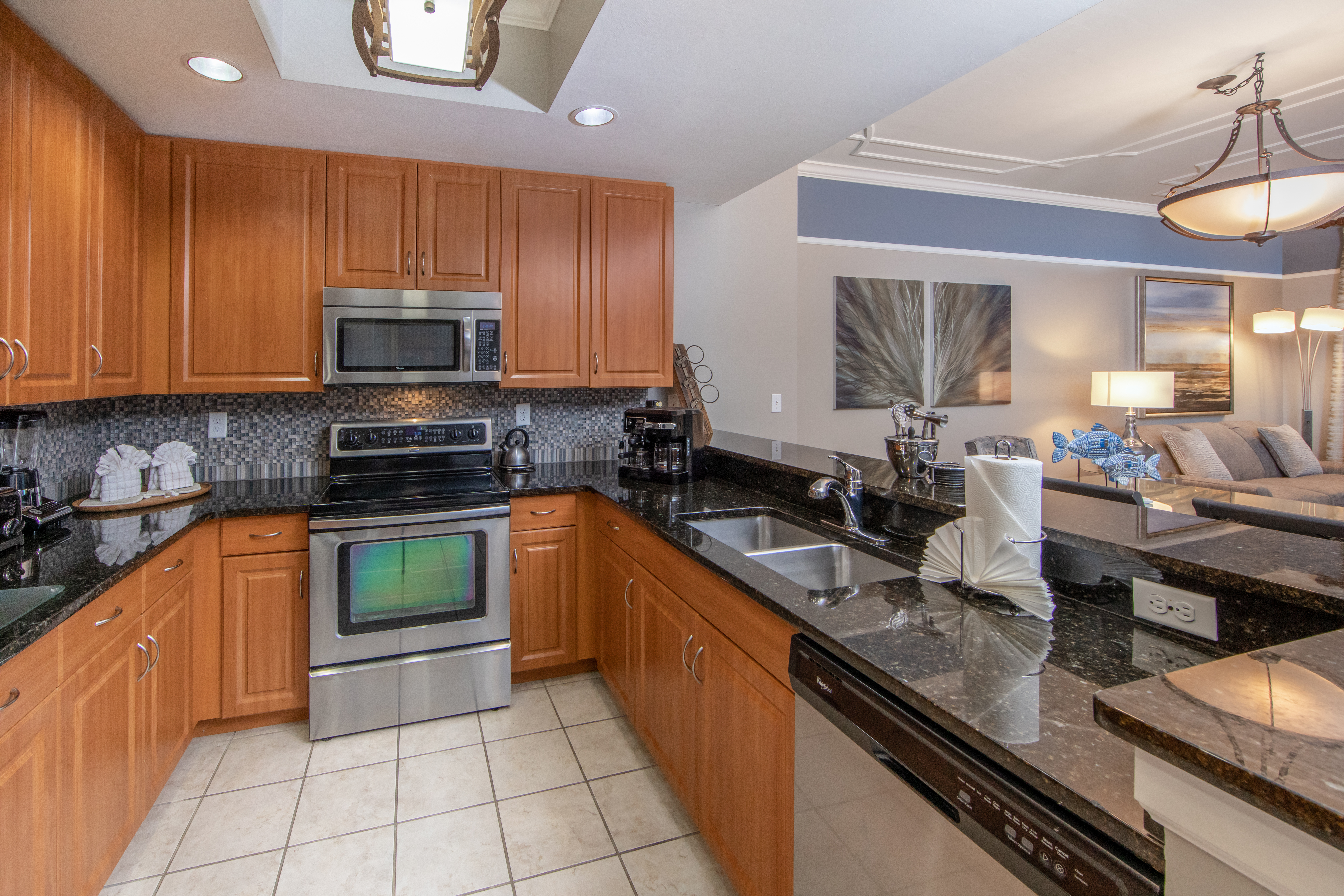 Full kitchen with stainless steel microwave, oven, and sink in a three-bedroom villa at Sunset Cove Resort in Marco Island, Florida