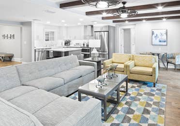 Living area with kitchen in background in a four-bedroom Signature Collection villa at Cape Canaveral Resort.
