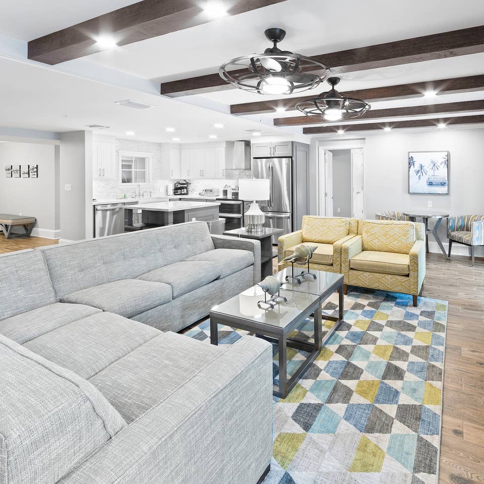 Living area with kitchen in background in a four-bedroom Signature Collection villa at Cape Canaveral Resort.