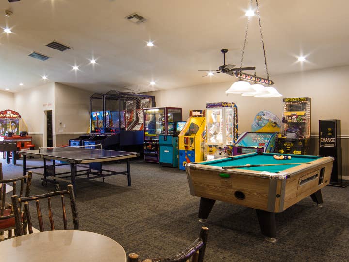 Game room with pool table, ping pong table and arcade games at Holiday Hills Resort in Branson, Missouri.