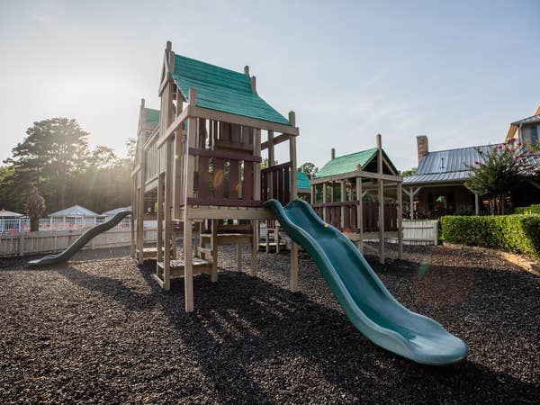 Outdoor playground with hunter green slides at Villages Resort in Flint, Texas