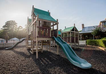 Outdoor playground with hunter green slides at Villages Resort in Flint, Texas