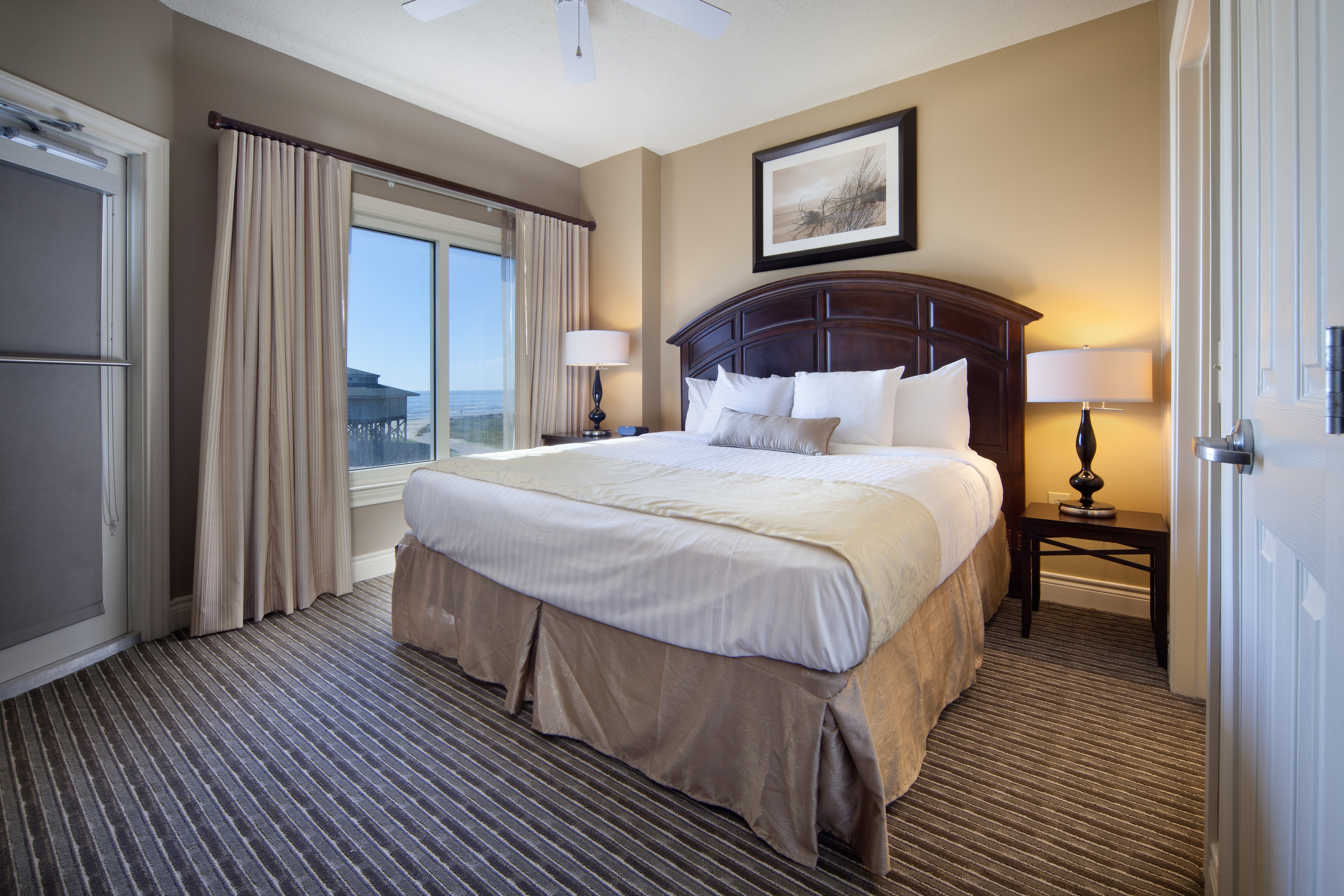 Guest bedroom with large window in a two-bedroom villa at Galveston Beach Resort