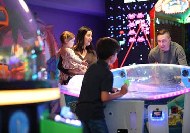 Family playing games in arcade at Orange Lake Resort near Orlando, Florida