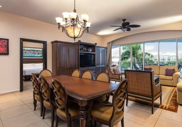 Breezy living and dining area with balcony and resort views.