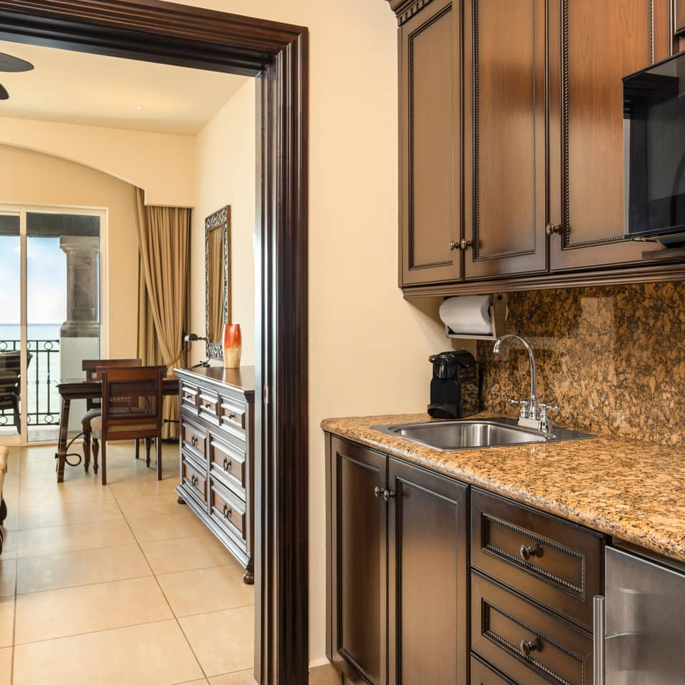 Kitchenette with dark wood cabinets and granite countertop.