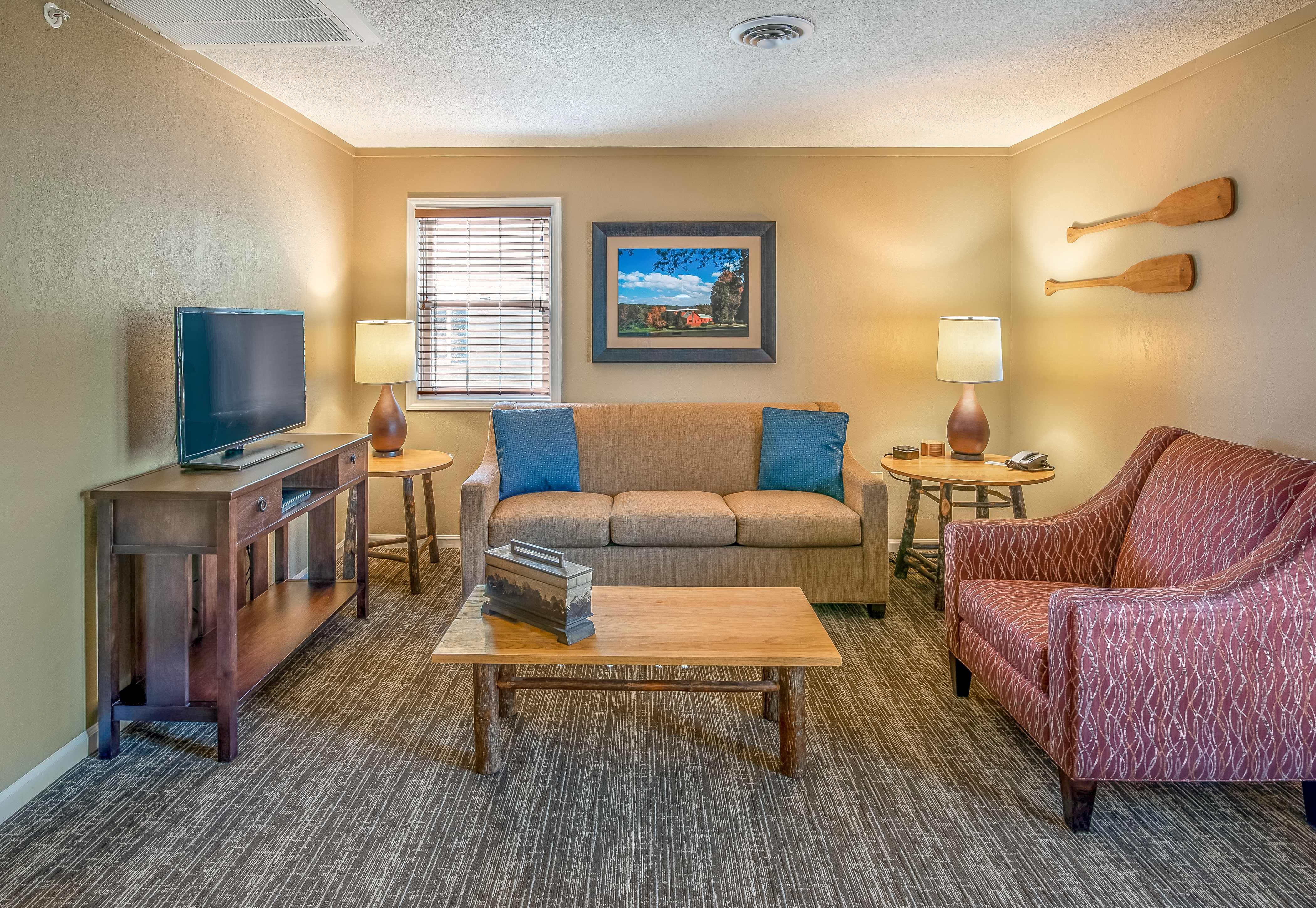 Living room with sofa, chair, and tv at Oak n' Spruce Resort in South Lee, Massachusetts