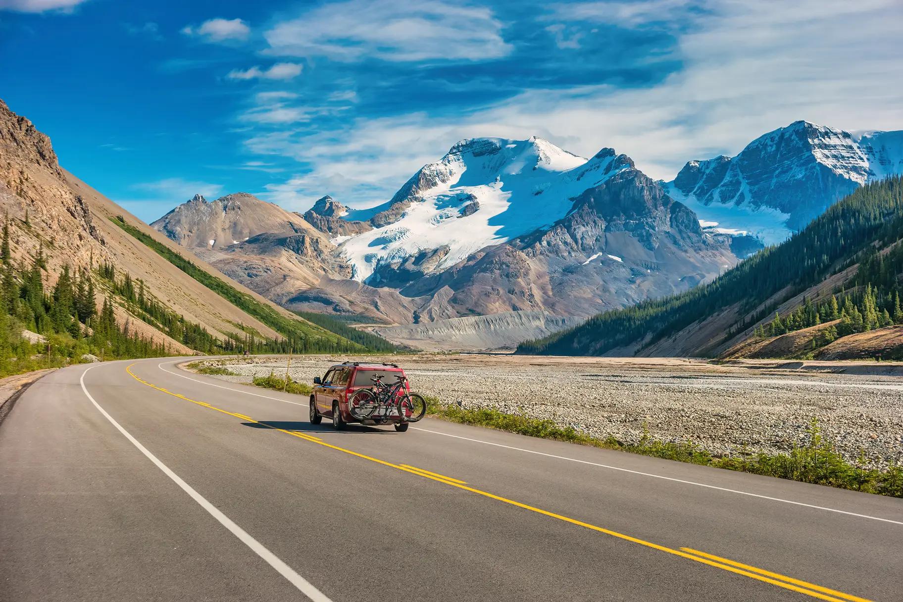 Car crusing down highway with mountains in the distance