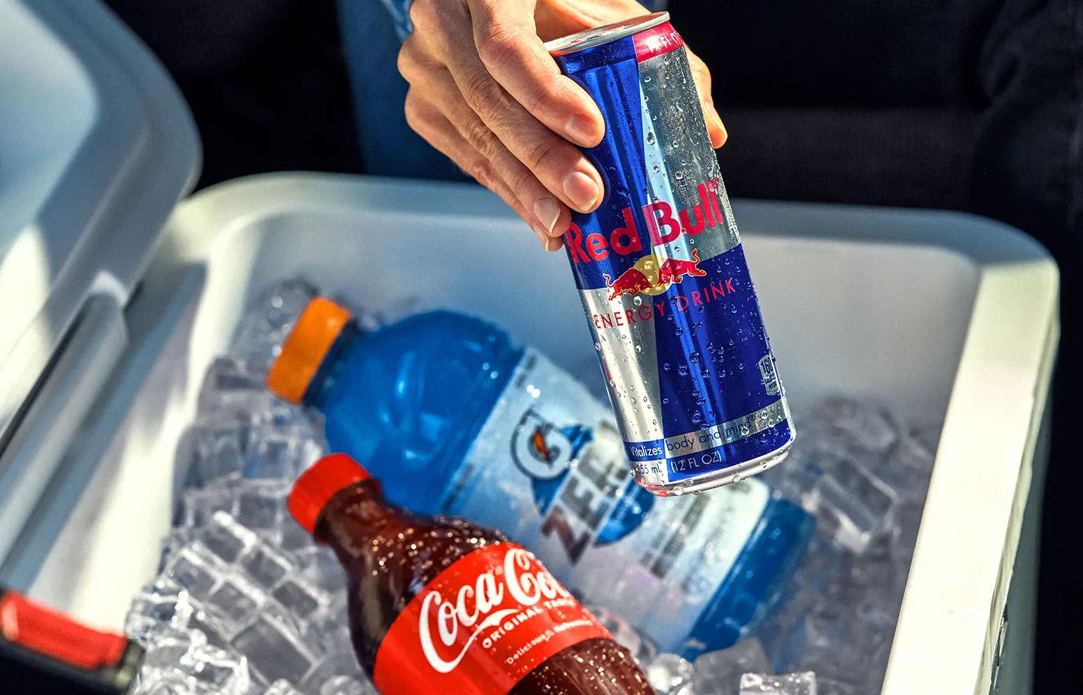 A driver reaches in a cooler for a Red Bull with a Coca-Cola and Gatorade.
