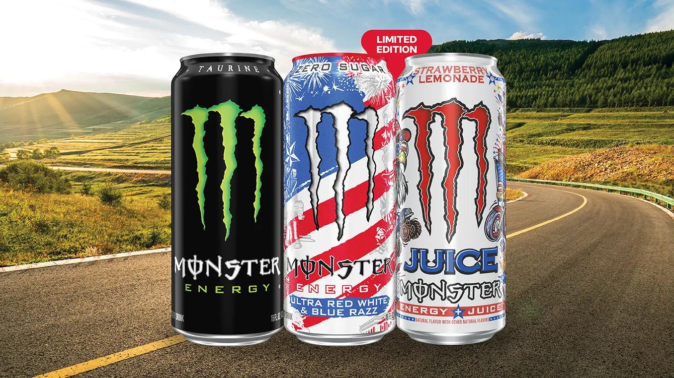 Three Monster Energy cans on the road.