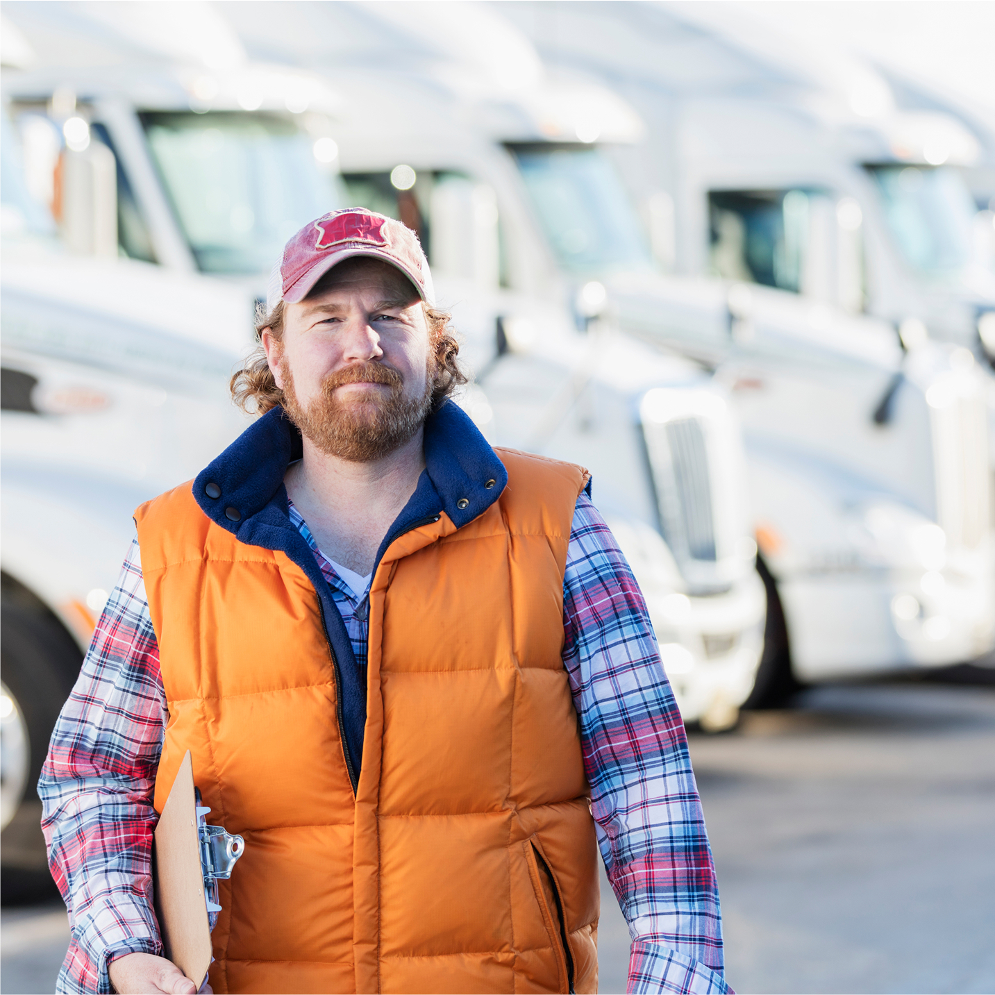 fleet manager standing in front a row of semi trucks