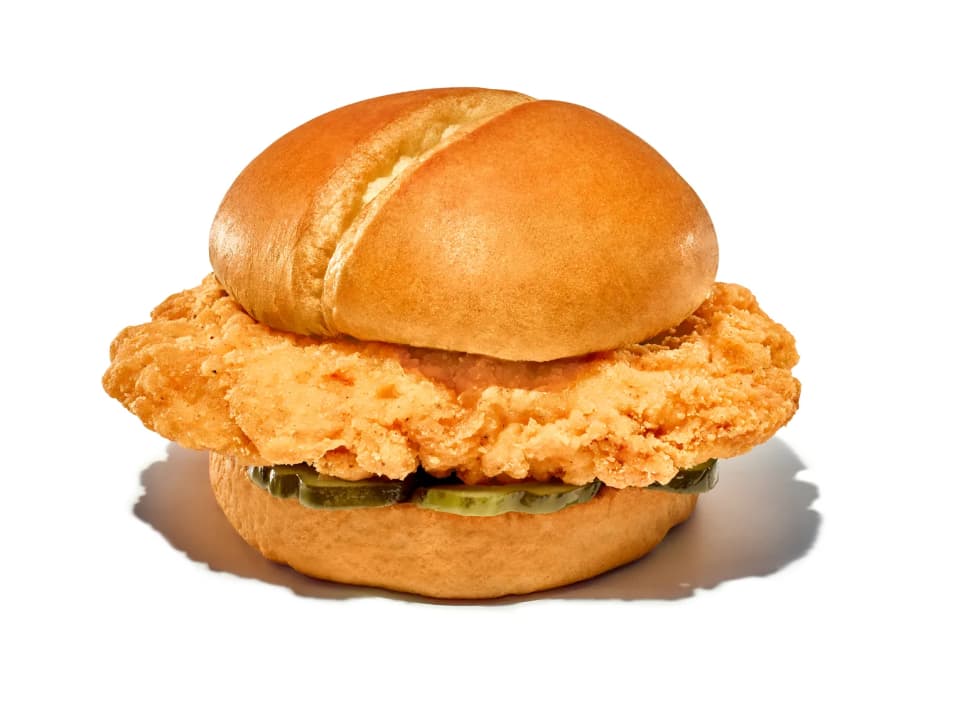 fried chicken sandwich with pickles on a brioche bun