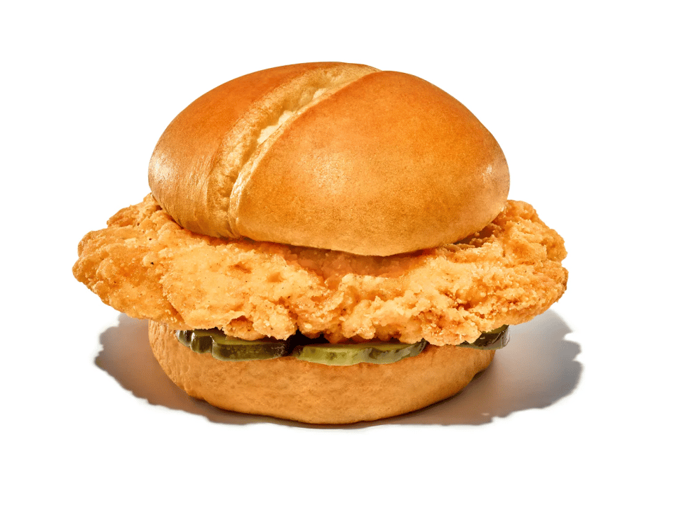 A crispy fried chicken sandwich with pickles on a white brioche bun
