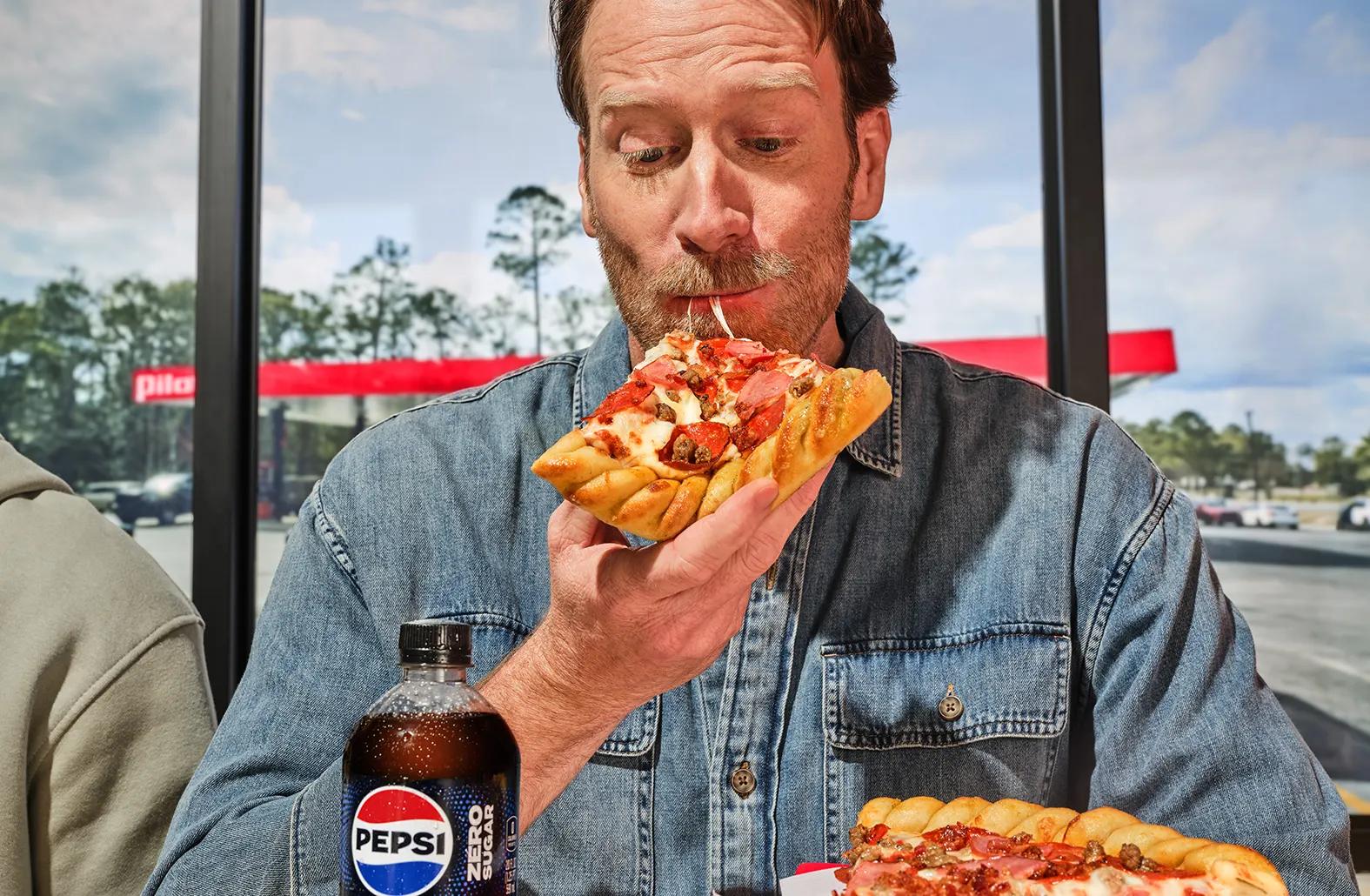 Man eating Pilot pizza with cheese pull