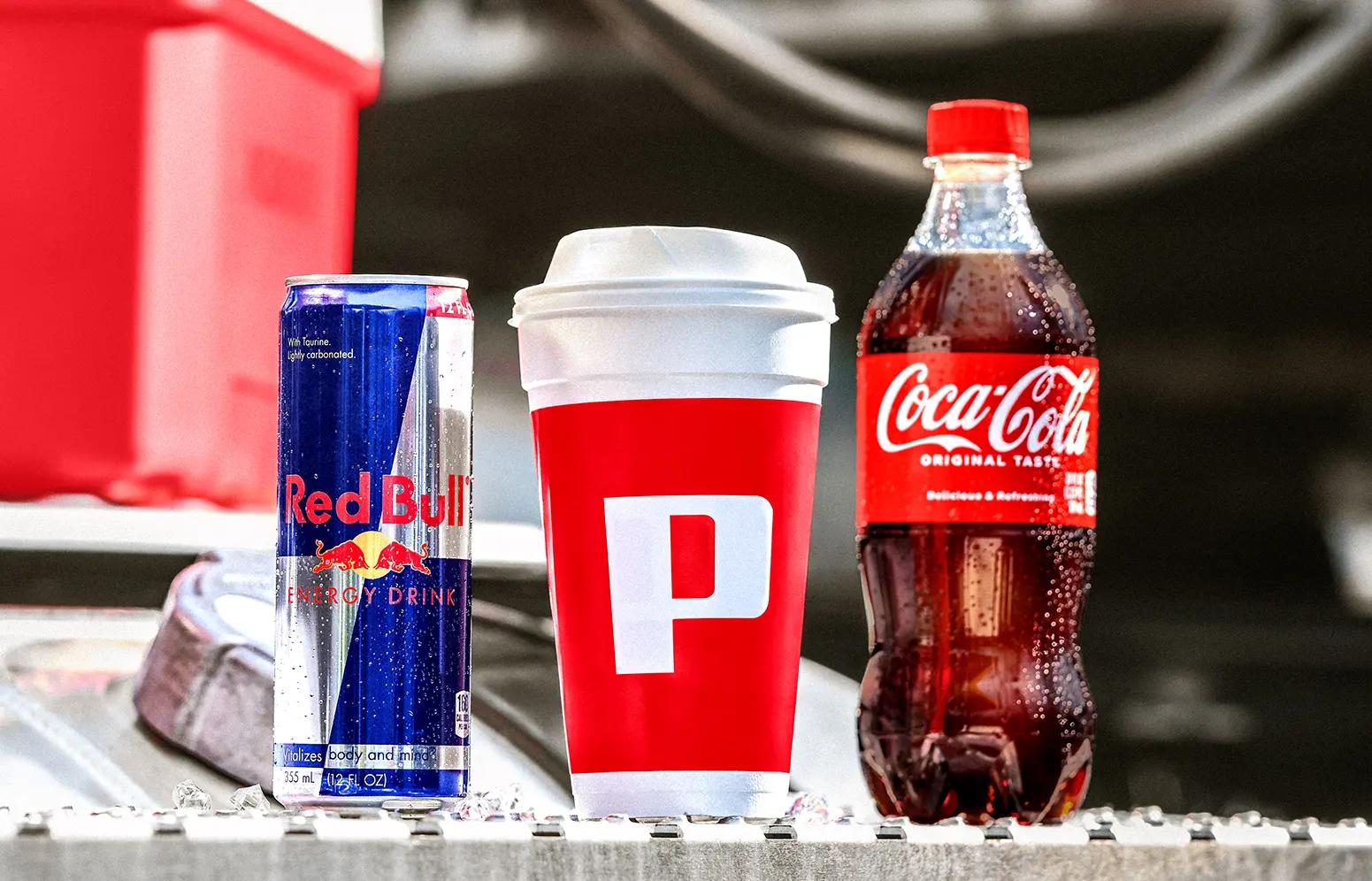 Drink lineup of Red Bull, Pilot cup, and Coca-Cola.