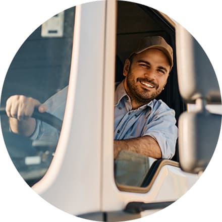 Man with hat leaning out driver side window smiling