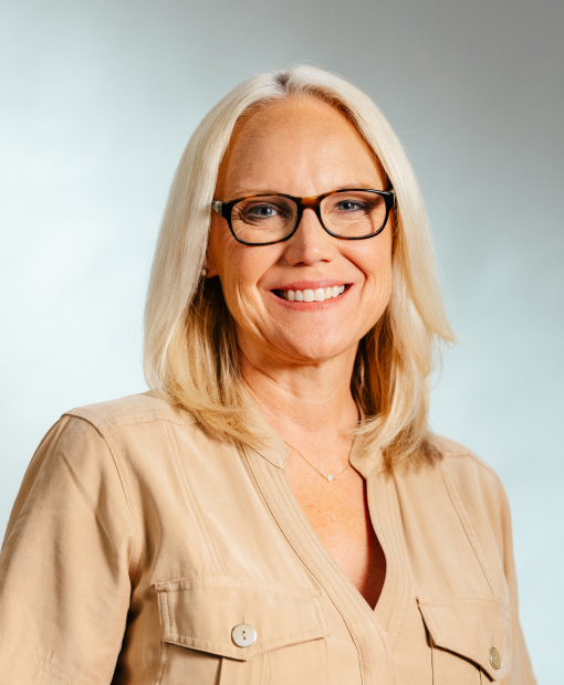 Professional headshot of Wendy Hamilton wearing a beige top and glasses