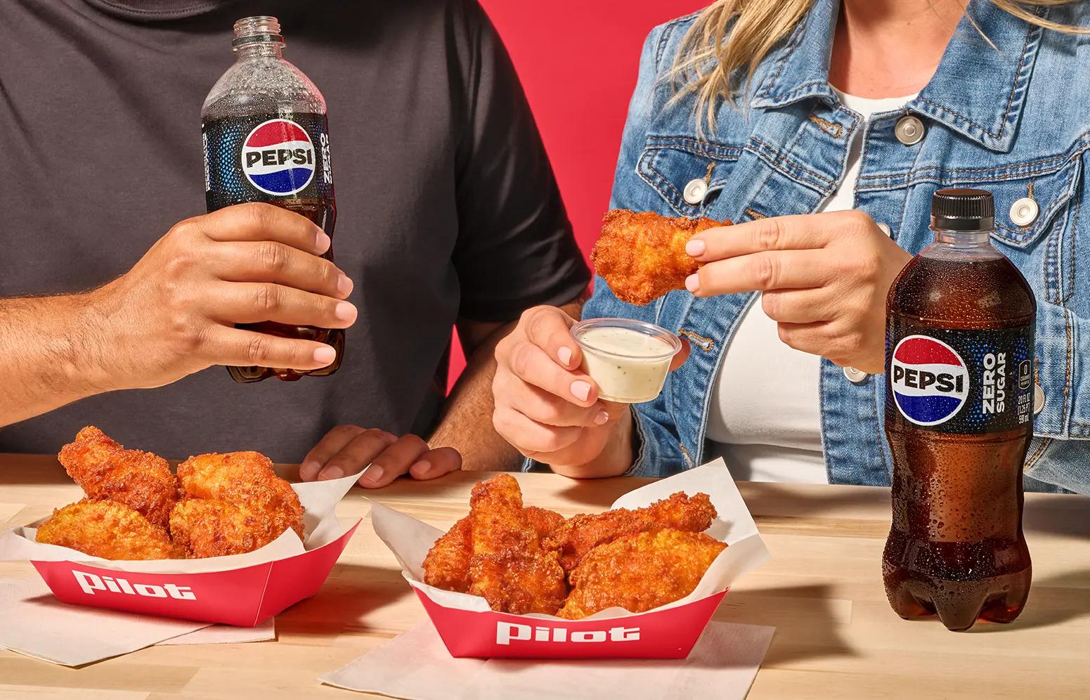 Two people eating the $8 Jumbo Wings Deal with a Pepsi and 5 jumbo chicken wings.