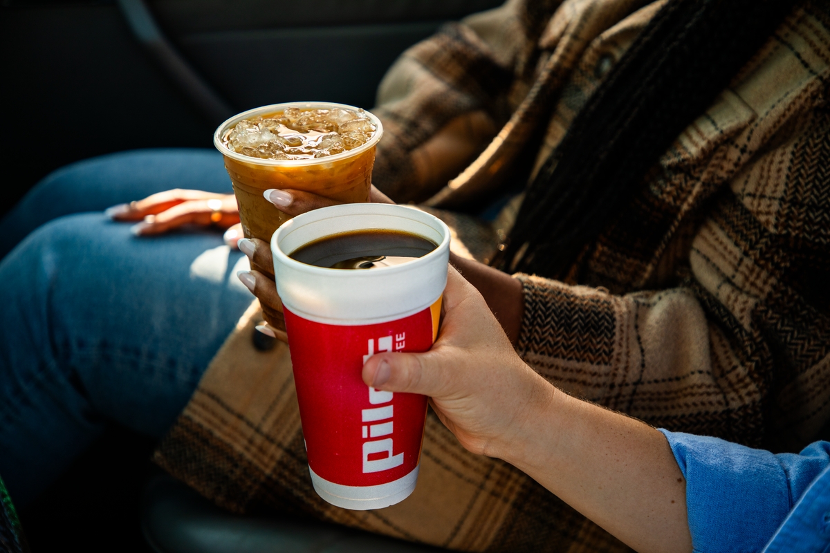Two people drinking coffee in their car