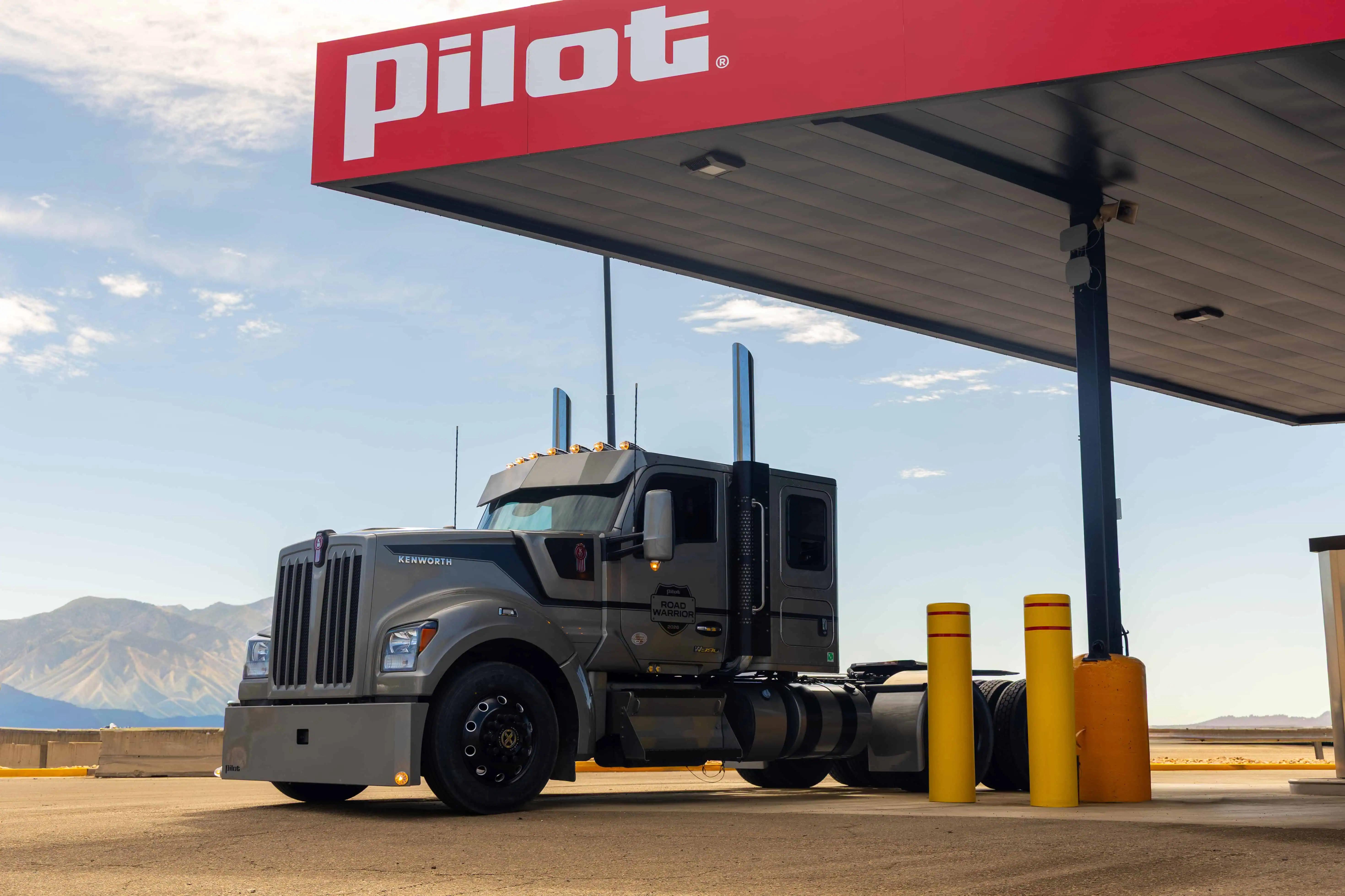 Gray Kenworth semi truck parked at a fuel pump