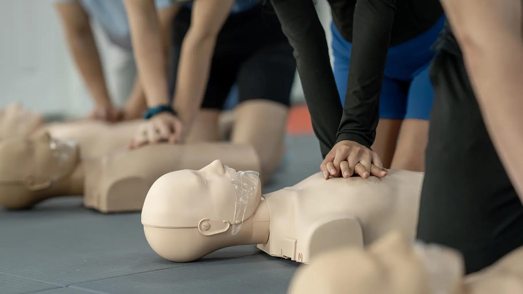 People in a CPR class practicing on manikins