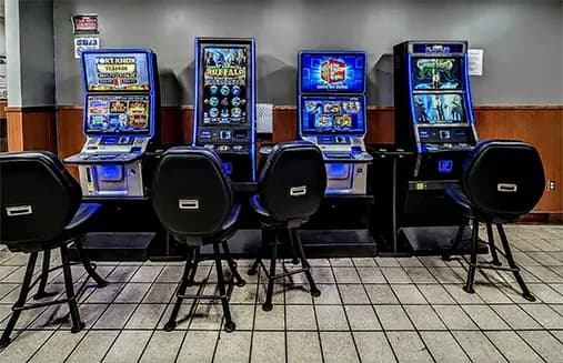 A row of game machines in a room with a tile floor