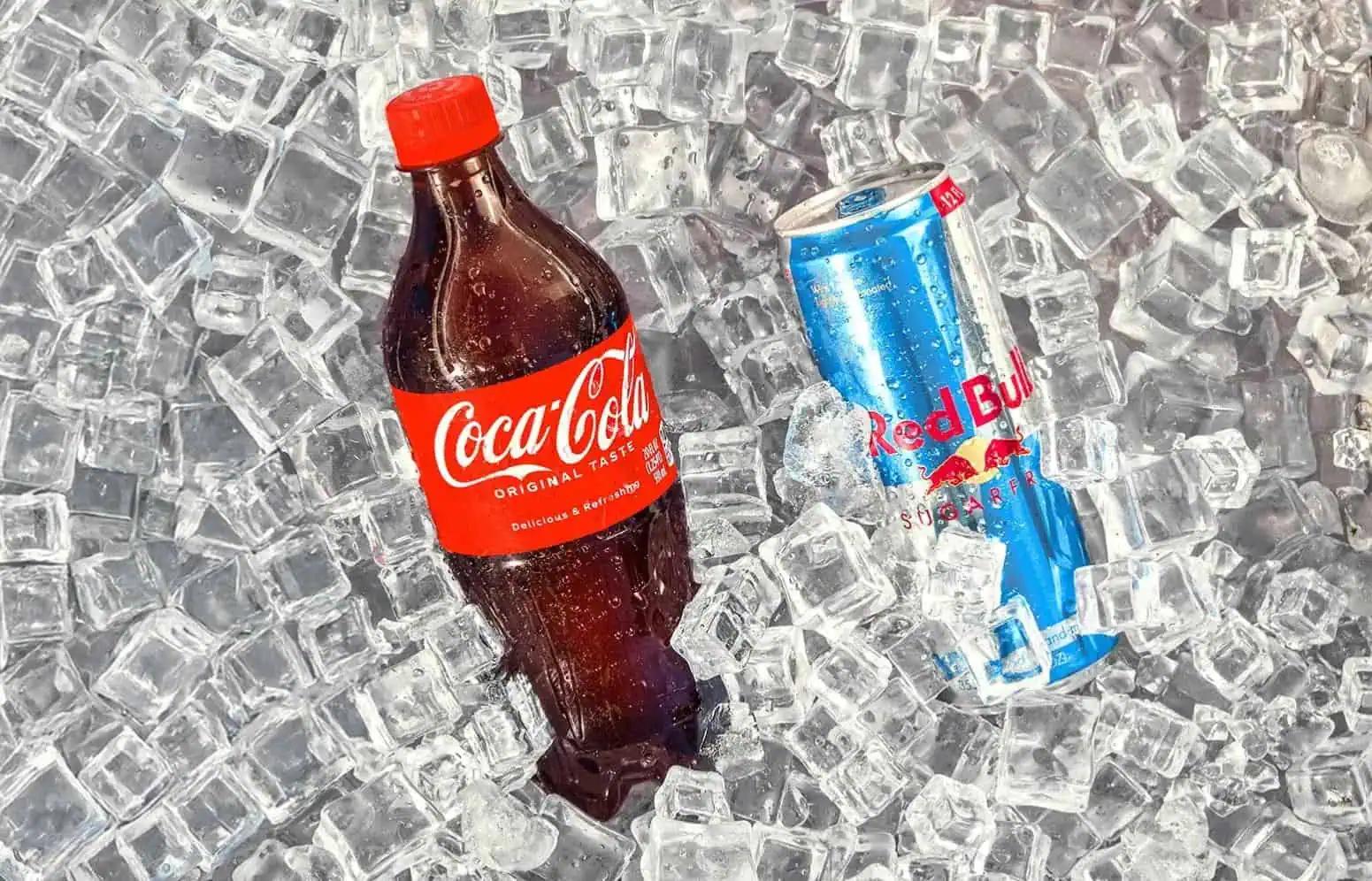 Ice-filled cooler with a Red Bull Energy Drink can, and a Coca-Cola Original Taste bottle.