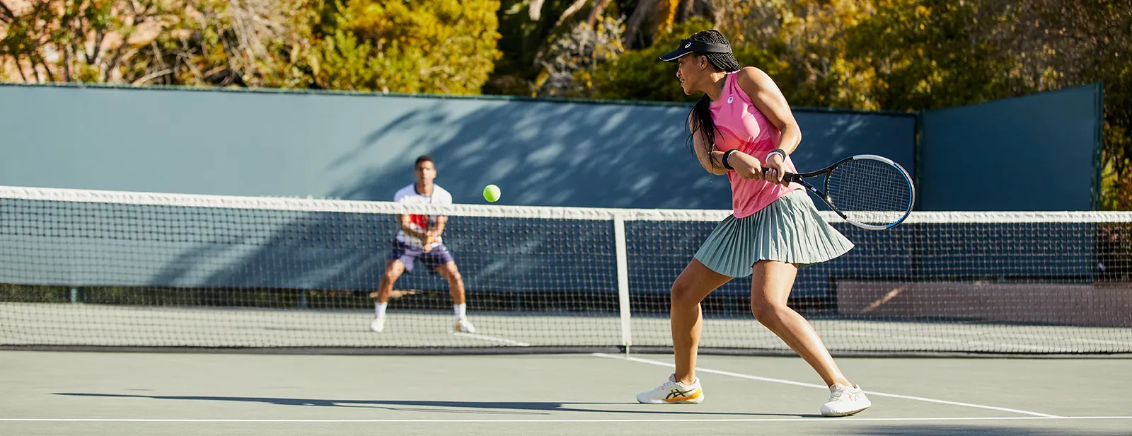 Women playing tennis outside in the heat