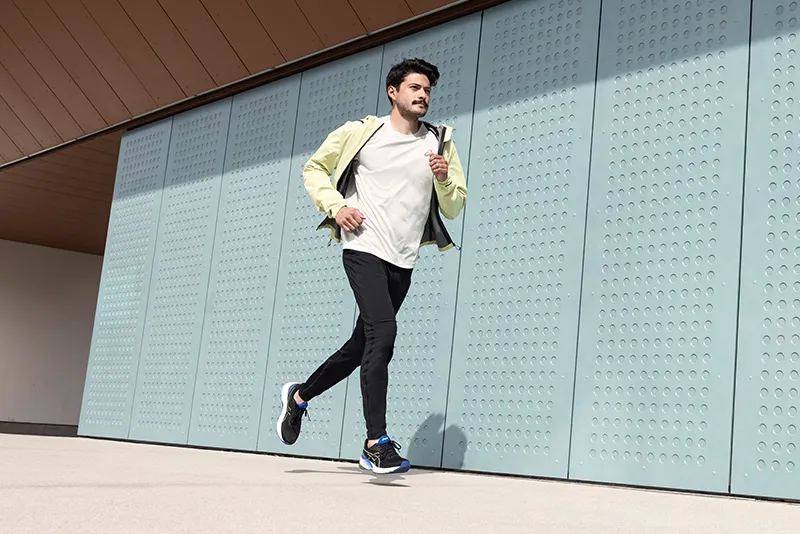 One runner running in a light jacket unzipped
