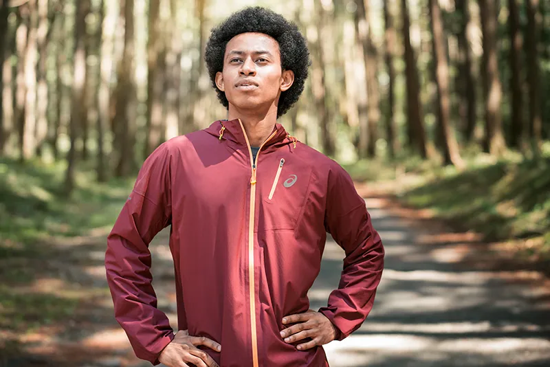 One runner standing in a trail with a light jacket