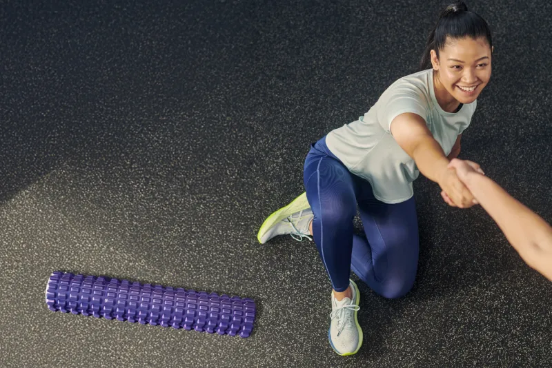 ASICS athlete stretching on the floor at the gym