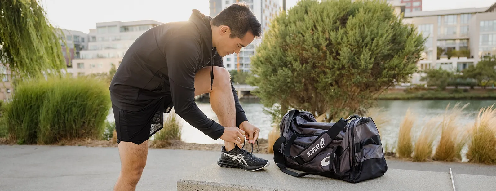 Man tieing his asics sneakers