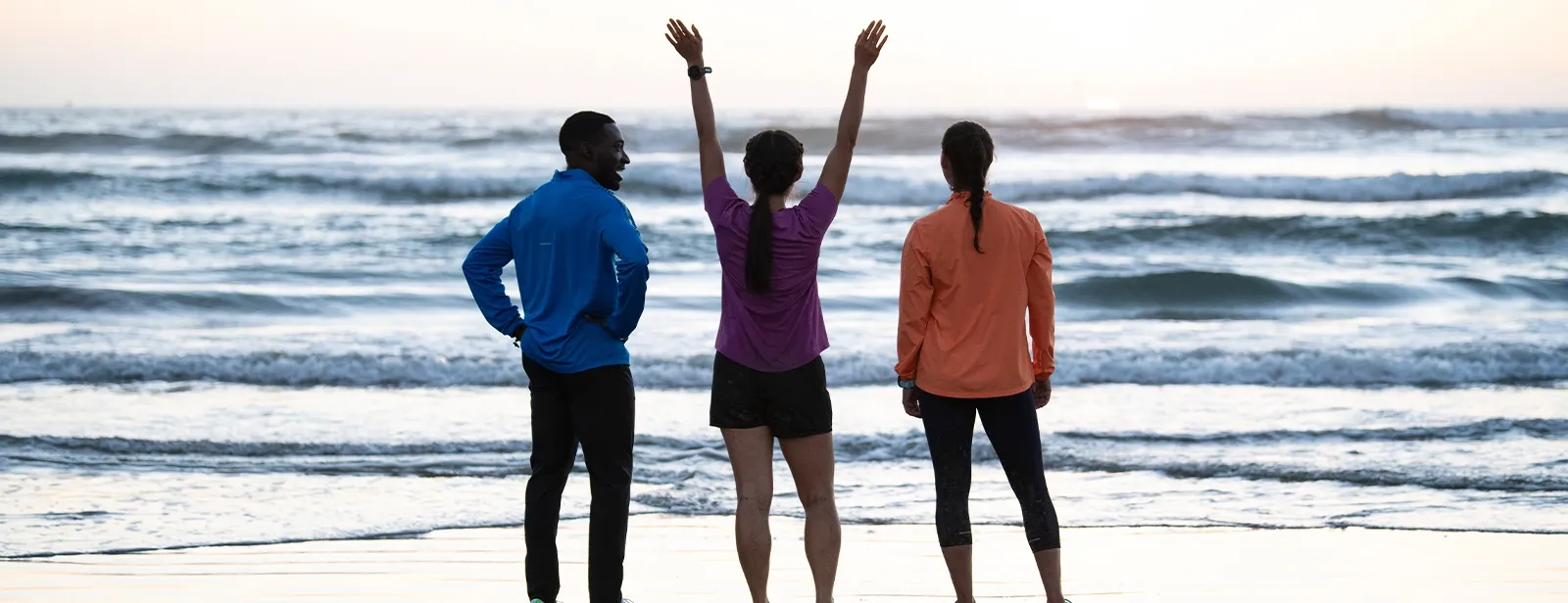 Three people standing next to water