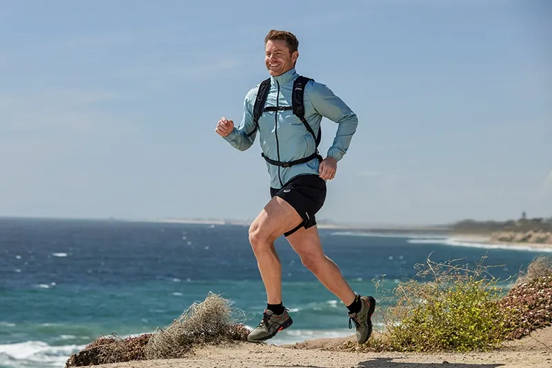 Man running the trails in ASICS gear