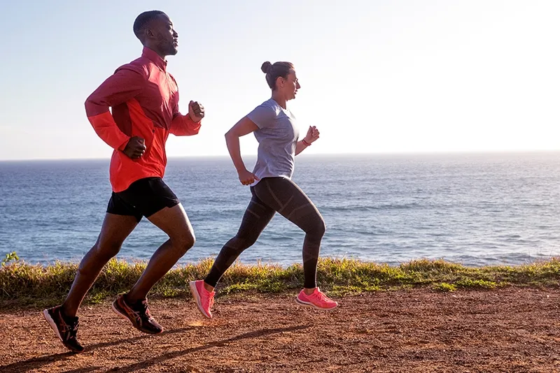 Two people running on a dirt road