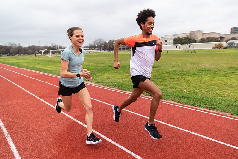 Two people running on the track