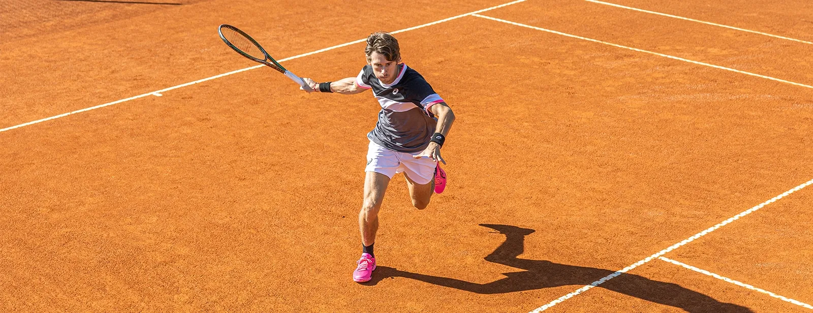 Man playing tennis wear ASICS gear