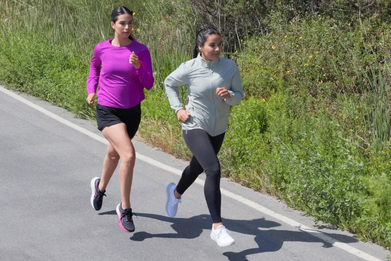 2 ASICS athletes running on the street