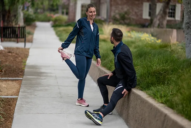 Two Runners stretching wearing ASICS tights