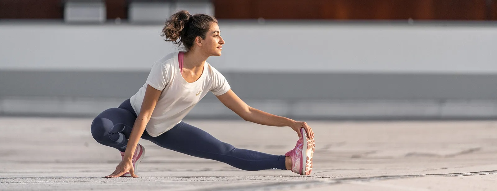 Runner stretching wearing ASICS tights
