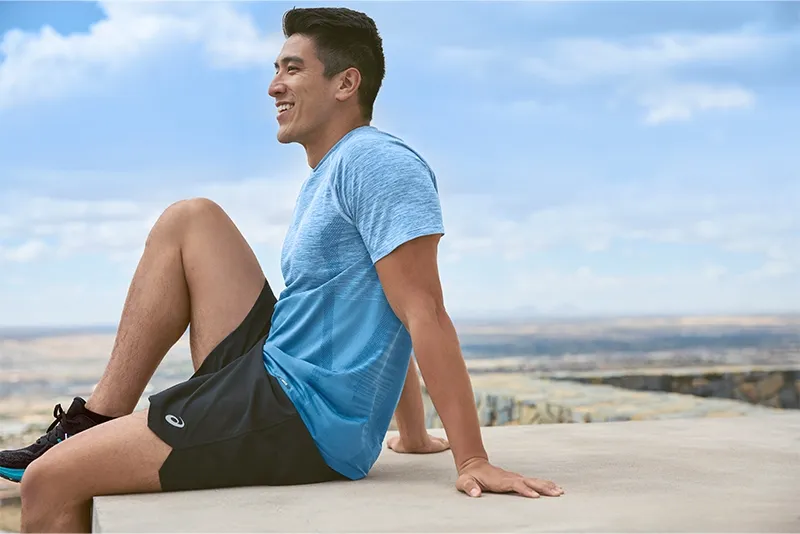 Man sitting outside wearing ASICS road short
