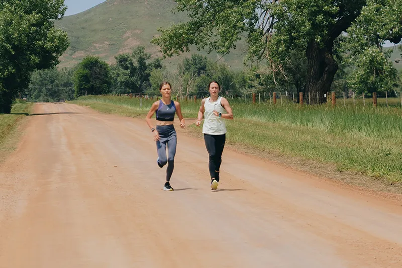 2 runners running on a path outside in Gel-Kayano 30 shoes